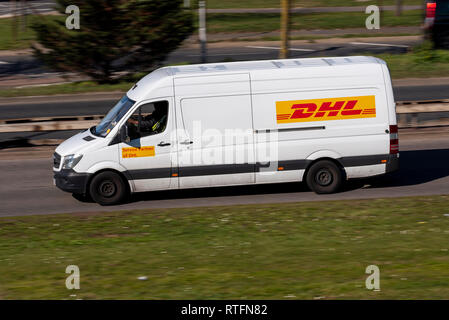 DHL-Transporter unterwegs. Weißes Fahrzeug. Servicepartner Stockfoto