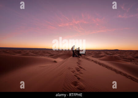 Menschen beobachten die fantastischen Sonnenaufgang in den Dünen Erg Chebbi in der Sahara. Schönen sand Landschaft mit herrlichem Himmel. Merzouga, Marokko Stockfoto