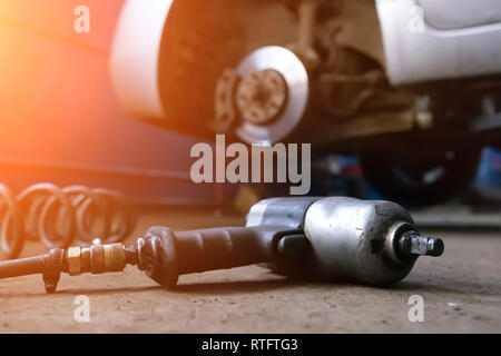 Automechaniker Mann mit elektrischer Schraubenzieher Reifenwechsel außerhalb. Car Service. Hände ersetzen Reifen auf Rädern. Reifenmontage Konzept. Stockfoto