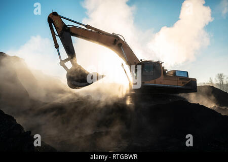 Gelb big Bagger in der Kohlengrube, lasten die Rasse, mit der hellen Sonne und blauen Himmel im Hintergrund. Mining Truck Bergbaumaschinen Stockfoto