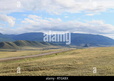 Weite Steppe mit gelben Gras unter einem blauen Himmel mit weißen Wolken Sajangebirge Sibirien Russland. schönen Hügel Stockfoto