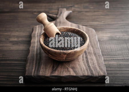Schwarz Roh Quinoa Samen in die hölzerne Schüssel auf Holz- Hintergrund closeup Stockfoto