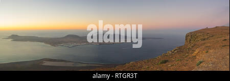 Blick vom Mirador del Rio auf Lanzarote bei Sonnenuntergang mit der Insel La Graciosa. Kanaren Stockfoto