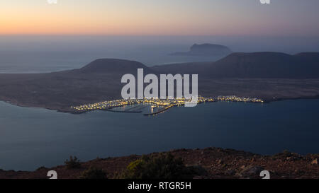 Blick vom Mirador del Rio auf Lanzarote bei Sonnenuntergang mit der Insel La Graciosa. Kanaren Stockfoto