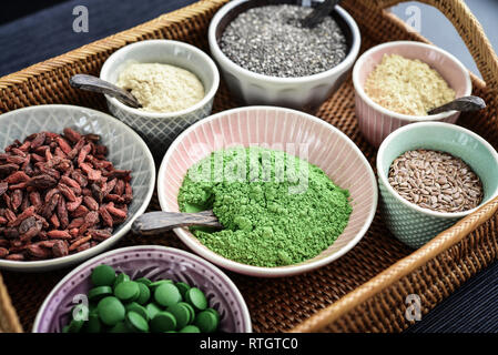 Verschiedene super Foods in Schalen auf einem rattan Fach, Ansicht von oben Stockfoto