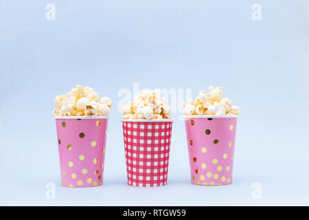 Mehrere Tassen Popcorn auf blauem Hintergrund Kopie Raum Stockfoto