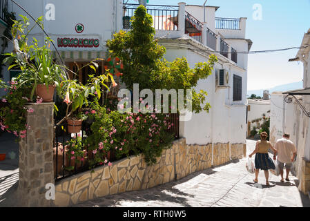 Ein Paar, die auf den Straßen von Mairena, einem kleinen Dorf auf einem Hügel in der Region Alpujarras in Andalucia, Spanien, spazieren gehen Stockfoto