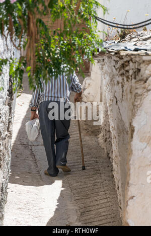 Ein alter Mann, der auf den Straßen von Mairena, einem kleinen Dorf auf einem Hügel in der Region Alpujarras in Andalucia, Spanien, spazieren geht Stockfoto