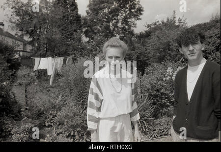 1970 s, dating.. eine ältere Teenager Paar stehen zusammen in einem englischen Vorort zurück Garten, England, UK. Stockfoto