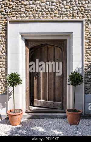 Aufgearbeitete Kloster aus dem 15. Jahrhundert Tür und Kalkstein umgeben von restaurierten mittelalterlichen Haus Stockfoto