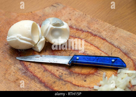 Gekochte Eier und ein Messer auf dem Schneidebrett in der Küche Stockfoto