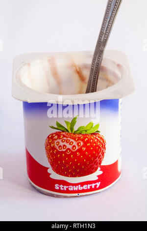 Leeren Topf von Yoplait Petits Filous aromatisiert Erdbeer Joghurt mit Löffel auf weißem Hintergrund - griechischen Stil Obst Schichten - Joghurt Stockfoto