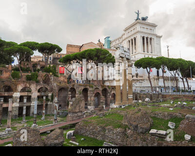 Blick von der Via dei Fori Imperiali zu Foro Di Cesare und Tempel der Venus Genetrix, Ruinen. In der Ferne sichtbaren weißen Palast Altar des Vaterlandes. Stockfoto