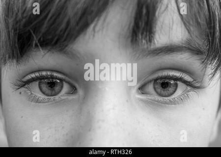 Schwarze und weiße Makroaufnahme der Großen intensive Augen eines jungen Kindes Stockfoto