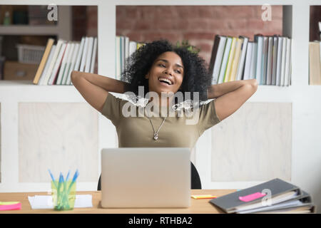 Gerne entspannt afrikanische amerikanische Arbeiterin mit fertiger Arbeit zufrieden Stockfoto
