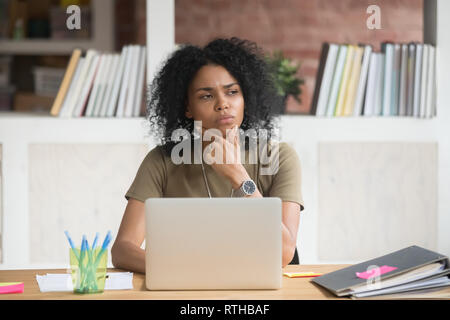 Nachdenklich , afrikanische Arbeiter Gefühl bei der Arbeit mit Laptop verwirrt Stockfoto