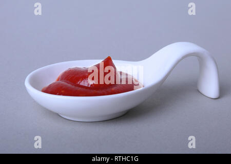 Weißes Porzellan Schüssel mit Ketchup oder Tomatensauce auf weißem Hintergrund. Stockfoto