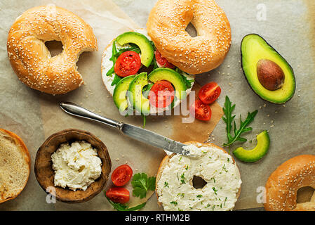 Vegetarische Bagel Sandwich mit Käse Creme, Avocado und Tomaten. Gesunde vegetarische und vegane Speisen. Stockfoto