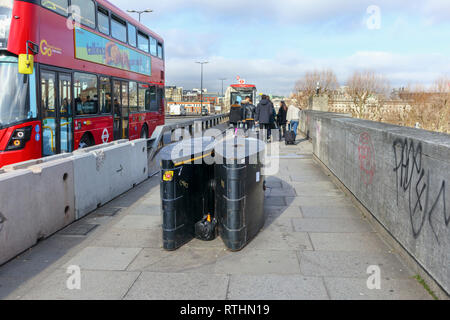 Anti-Fahrzeug Poller, einer Anti-terror-Sicherheit messen, auf dem Gehsteig der Waterloo Bridge, Lambeth, London SE1, red London Bus Stockfoto