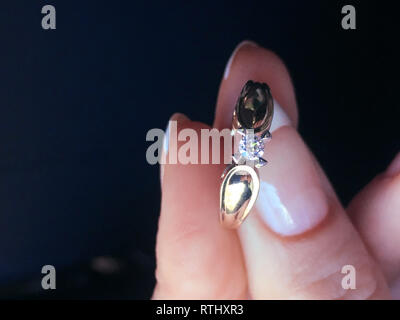 In der Nähe von eleganten Diamond Ring am Finger mit grauen Schal Hintergrund. Diamond Ring. Stockfoto