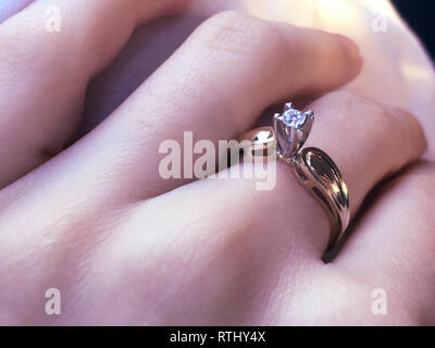 In der Nähe von eleganten Diamond Ring am Finger mit grauen Schal Hintergrund. Diamond Ring. Stockfoto