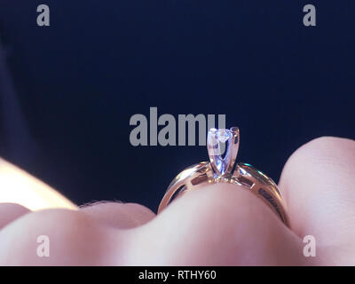 In der Nähe von eleganten Diamond Ring am Finger mit grauen Schal Hintergrund. Diamond Ring. Stockfoto