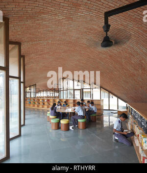 Innenansicht mit Studenten bei der Arbeit. Maya Somaiya Bibliothek, Kopargaon/Maharashtra, Indien. Architekt: Sameep Padora und Associates (SP+A), 2018. Stockfoto