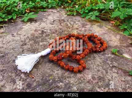 Rosenkranz auf dem hölzernen Hintergrund. Rudraksha Mala für Mantras. 108 Perlen. Stockfoto