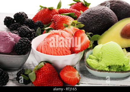 Satz von Eis Kugeln in verschiedenen Farben und Geschmacksrichtungen mit Beeren, Schokolade und Früchte auf dem Tisch Stockfoto