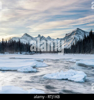 Lange Belichtung Bild des Athabasca River, oberhalb der Athabasca Falls, bei Sonnenaufgang im Winter mit Schnee bedeckt Banken, Jasper National Park, Kanada Stockfoto
