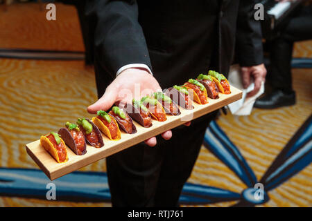 Ein Kellner mit einem Tablett voller taco Vorspeisen - Hochzeit catering Serie Stockfoto