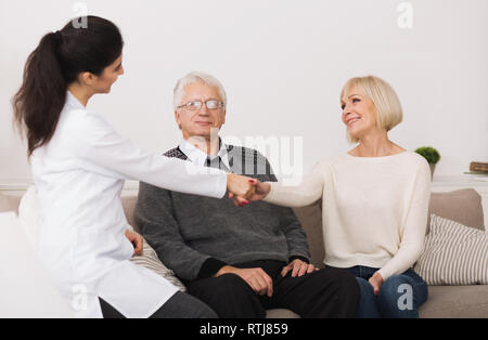 Senior Paar einladende Doktor während Home Besuch Stockfoto