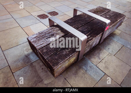 Zeitgenössische Holzblock und Stahl Sitzbank neben dem Regents Canal in der Nähe von Kohle Tropfen Yard, Kings Cross, London Stockfoto