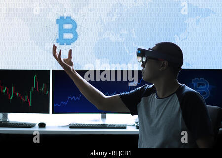 Die Erfahrung der Virtuellen Realität Welt mit hololens 1 | Control Bitcoin Währung in der Hand Stockfoto