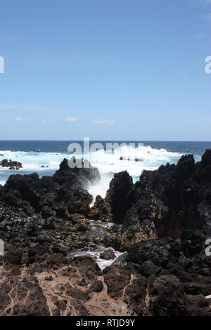 Wellen, die in Lava Rock am Ufer des Laupahoehoe Point auf der Hamakua Coast, Hawaii, USA Stockfoto