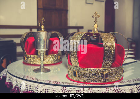 Hochzeit goldene Kronen und alten Kelch bereit für die Trauung in der serbisch-orthodoxen Kirche. Stockfoto