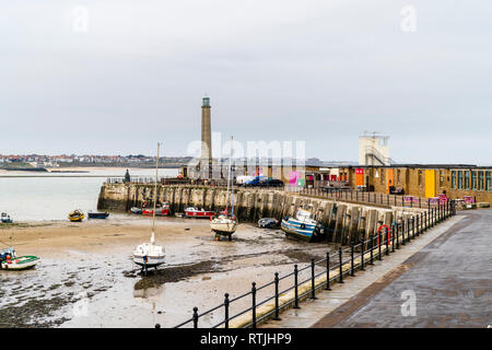 Margate Hafen bei Ebbe. Single gekrümmten Stein Bootsanleger mit kleinen Leuchtturm am Ende die verschiedenen kleinen Booten und Angeln smacks auf Sand auf den Strand gesetzt. Stockfoto