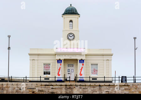 Margate Fremdenverkehrsamt, Droit Haus, doppelt verglasten Gebäude mit Uhrturm auf dem steinernen Pier. Bedeckt grauer Himmel. Stockfoto