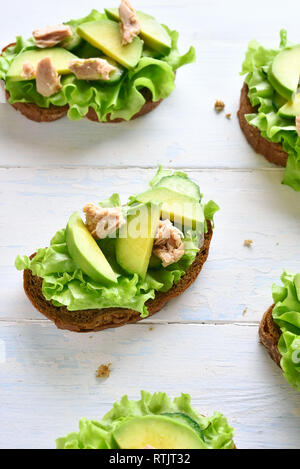 Sandwichs mit Thunfisch, Avocado und Salatblätter öffnen. Lecker Thunfisch Brötchen zum Frühstück. Gesunden Snack. Stockfoto