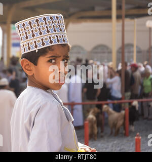 Nizwa, Oman - November 2, 2018: Portrait Kind drehte sich um die von der Kamera am Freitag Tiermarkt in Nizwa überrascht Stockfoto