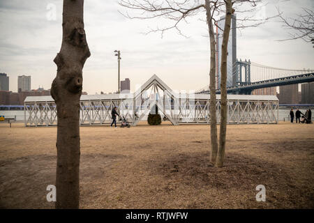 Siah Armajanis experiential öffentliche Kunst Skulptur", Brücke über den Baum" wird von den Besuchern zu Brooklyn Bridge Park genossen, zwischen Manhattan und Brooklyn Brücken, in New York am Samstag, 23. Februar 2019. Die 91-Fuß langen Stück mit Treppe in der Mitte hebt die Teilnehmer über einen einsamen immergrüner Baum und es ist das erste Mal, dass die 1970 Stück in fast 50 Jahren angezeigt worden ist. Die Met Breuer ist Hosting eine Retrospektive der Minneapolis arbeiten Künstler' und 'Brücke über Baum' auf dem Display im Park bis 29. September. (Â© Richard B. Levine) Stockfoto