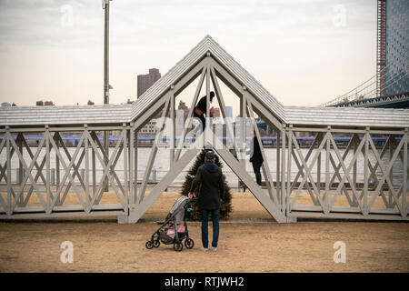 Siah Armajanis experiential öffentliche Kunst Skulptur", Brücke über den Baum" wird von den Besuchern zu Brooklyn Bridge Park genossen, zwischen Manhattan und Brooklyn Brücken, in New York am Samstag, 23. Februar 2019. Die 91-Fuß langen Stück mit Treppe in der Mitte hebt die Teilnehmer über einen einsamen immergrüner Baum und es ist das erste Mal, dass die 1970 Stück in fast 50 Jahren angezeigt worden ist. Die Met Breuer ist Hosting eine Retrospektive der Minneapolis arbeiten Künstler' und 'Brücke über Baum' auf dem Display im Park bis 29. September. (Â© Richard B. Levine) Stockfoto