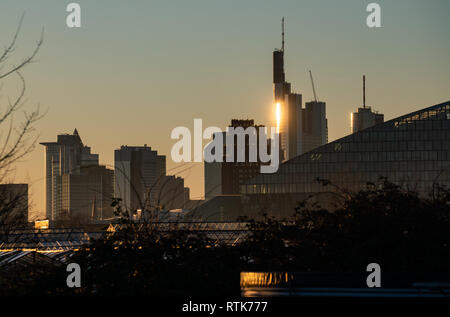 27. Februar 2019, Hessen, Frankfurt/Main: Die Frankfurter Wolkenkratzer in der untergehenden Sonne am Abend Licht. Foto: Frank Rumpenhorst/dpa Stockfoto