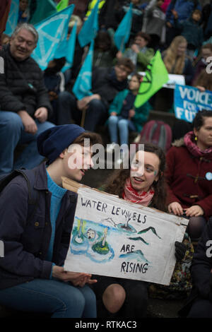 Glasgow, Schottland, 2. März 2019. Das "Blue Wave" Demonstration vom Aussterben Rebellion Klimawandel Gruppe und Unterstützer, blockieren Straßen und bewegen sich durch die Straßen der Stadt das steigende Wasser des Flusses Clyde zu markieren und auf die Gefahren des Klimawandels zu warnen, wenn dringende Maßnahmen nicht sofort ergriffen werden. Die friedliche Demonstration von ca. 200 Menschen kulminierte mit dem symbolischen Werfen von Wasser aus dem Fluss Clyde auf die Stadt schritte Kammern, ein Symbol für die Wasserstände zu kommen. In Glasgow, Schottland. Quelle: Jeremy Sutton-Hibbert / alamy Leben Nachrichten. Stockfoto