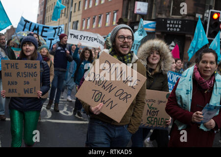 Glasgow, Schottland, 2. März 2019. Das "Blue Wave" Demonstration vom Aussterben Rebellion Klimawandel Gruppe und Unterstützer, blockieren Straßen und bewegen sich durch die Straßen der Stadt das steigende Wasser des Flusses Clyde zu markieren und auf die Gefahren des Klimawandels zu warnen, wenn dringende Maßnahmen nicht sofort ergriffen werden. Die friedliche Demonstration von ca. 200 Menschen kulminierte mit dem symbolischen Werfen von Wasser aus dem Fluss Clyde auf die Stadt schritte Kammern, ein Symbol für die Wasserstände zu kommen. In Glasgow, Schottland. Quelle: Jeremy Sutton-Hibbert / alamy Leben Nachrichten. Stockfoto