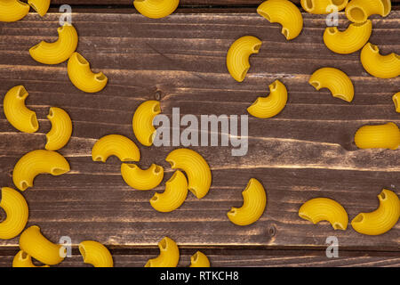 Menge ganze rohe Nudeln Pipe Rigate Vielzahl flatlay auf braunem Holz Stockfoto