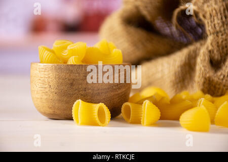 Menge ganze rohe Nudeln Pipe Rigate Sorte mit holzschale in Weiß Küche Stockfoto