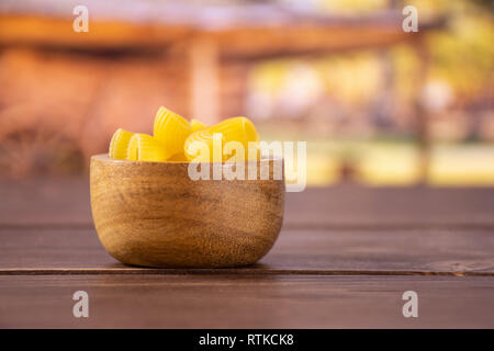 Menge ganze rohe Nudeln Pipe Rigate Sorte mit Holzschale mit Warenkorb Stockfoto