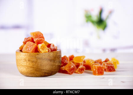 Viele Schichten von trockenen Papaya mit Holzschale mit roten Blumen auf Weiß Stockfoto