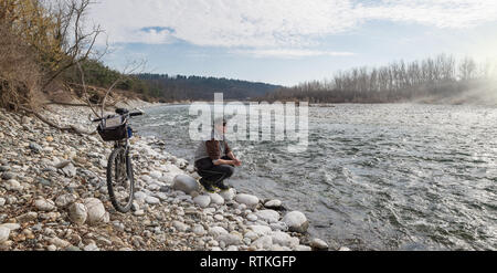 Mann mit dem Mountainbike auf den Fluss. Ticino, Italien Stockfoto